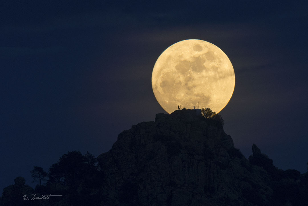 The featured image shows a full moon over a mountain containing
a person looking through a small telescope. The rollover highlights
features on the Moon the create the 