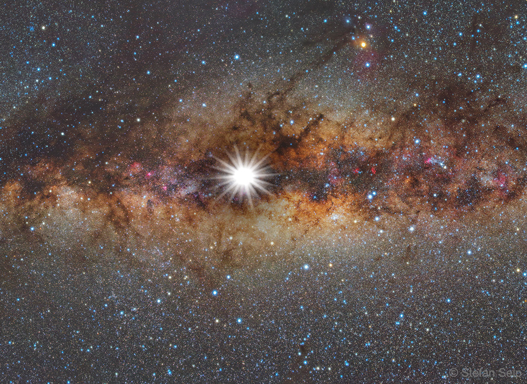 The featured image shows a composite image of the Sun
superposed on the Milky Way. The image shows the night sky
you would see if the Sun was very dim. 
Please see the explanation for more detailed information.