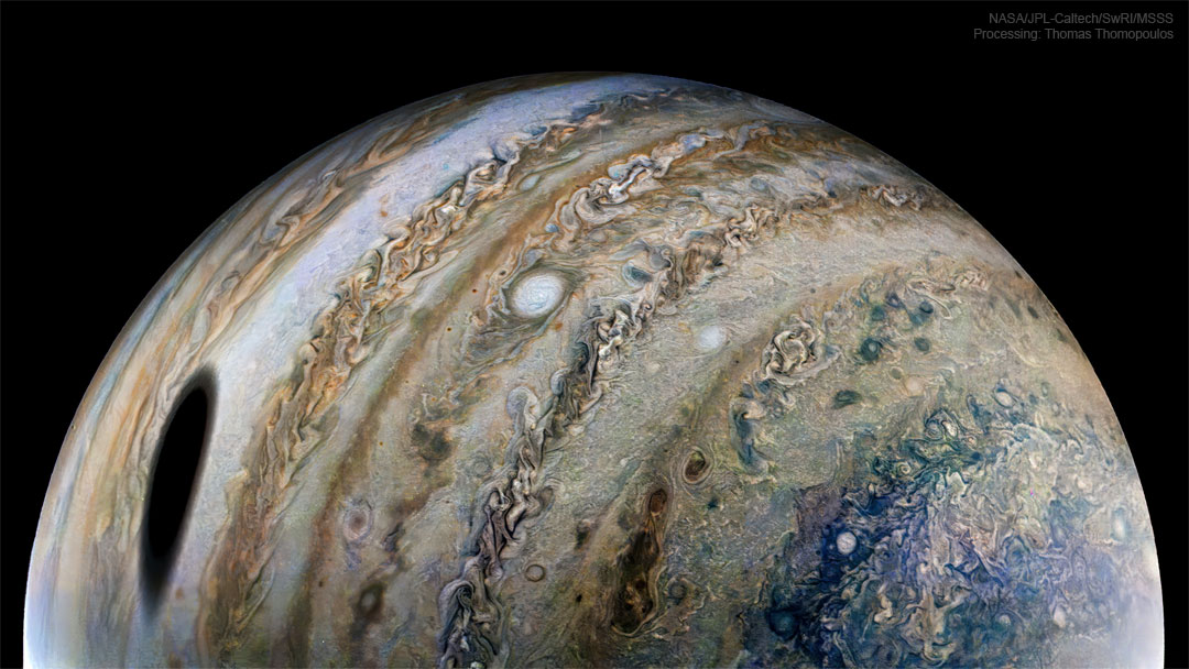 The featured image shows the planet Jupiter as
seen by NASA's passing robotic spaceship Juno. A large
dark spot seen on Jupiter is the shadow of Jupiter's
moon Io.
Please see the explanation for more detailed information.