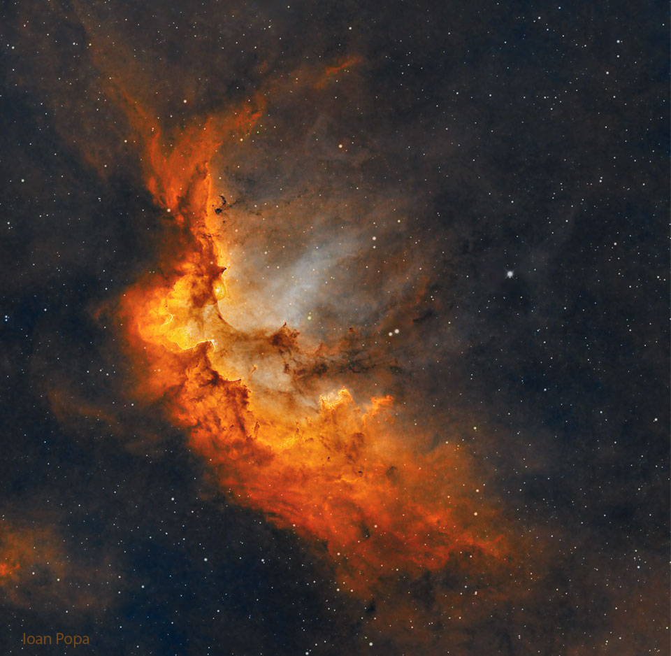 The featured image shows the a red-glowing
Wizard Nebula with gas and dust pillars in a starry
background. 
Please see the explanation for more detailed information.