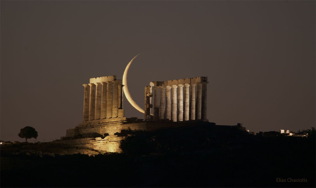 A picture of the remnant pillars of Poseiden is shown, an 
ancient Greek Temple. In the middle of the ruins, far in the 
distance, is a crescent Moon.
Please see the explanation for more detailed information.