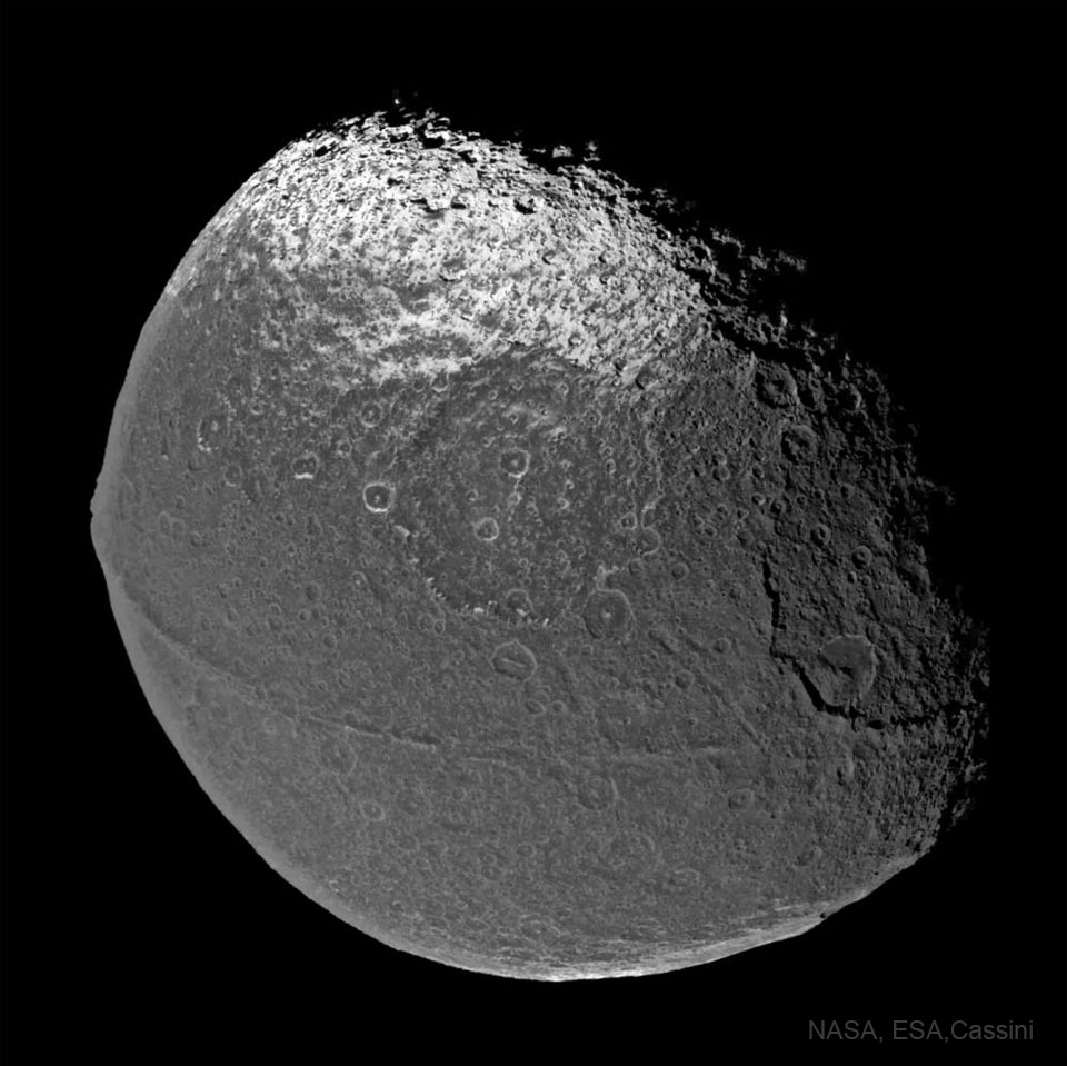 An unusual two-toned ball is pictured. The ball, Saturn's
moon Iapetus, has many craters and an unusual ridge running along
its equator that makes it look like a walnut.
Please see the explanation for more detailed information.