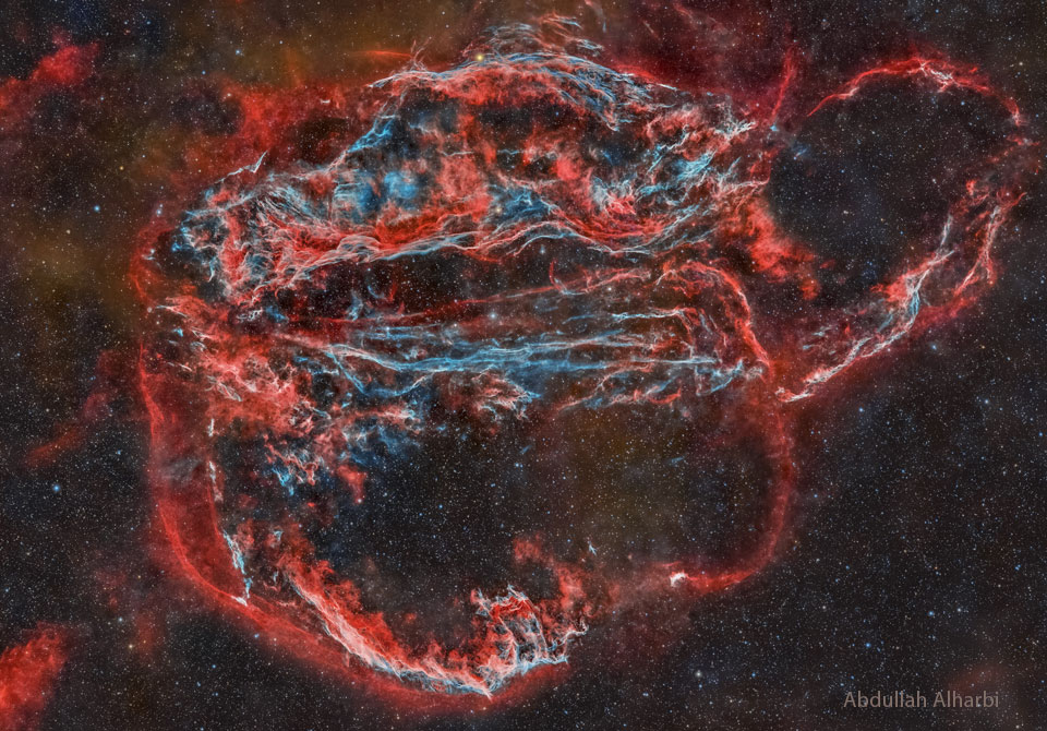 The featured image shows a night sky with a large
complex nebula in red and blue. The Veil Nebula has several famous
components such as the Bat and Witch's Broom Nebulas. 
Please see the explanation for more detailed information.
