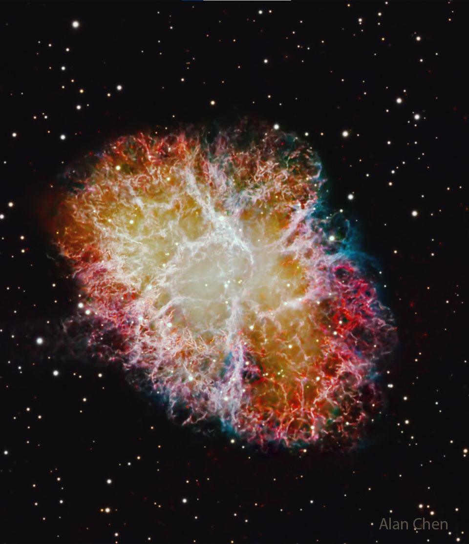 A dark starfield surrounds a colorful nebula filled with
tangled filaments.  
Please see the explanation for more detailed information.