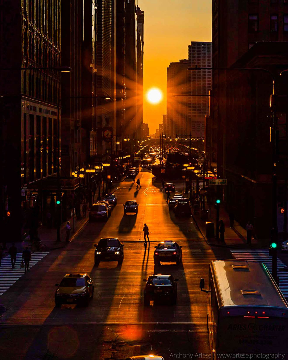 A picture of the Sun setting at the end of a long
city street is shown. 
Please see the explanation for more detailed information.