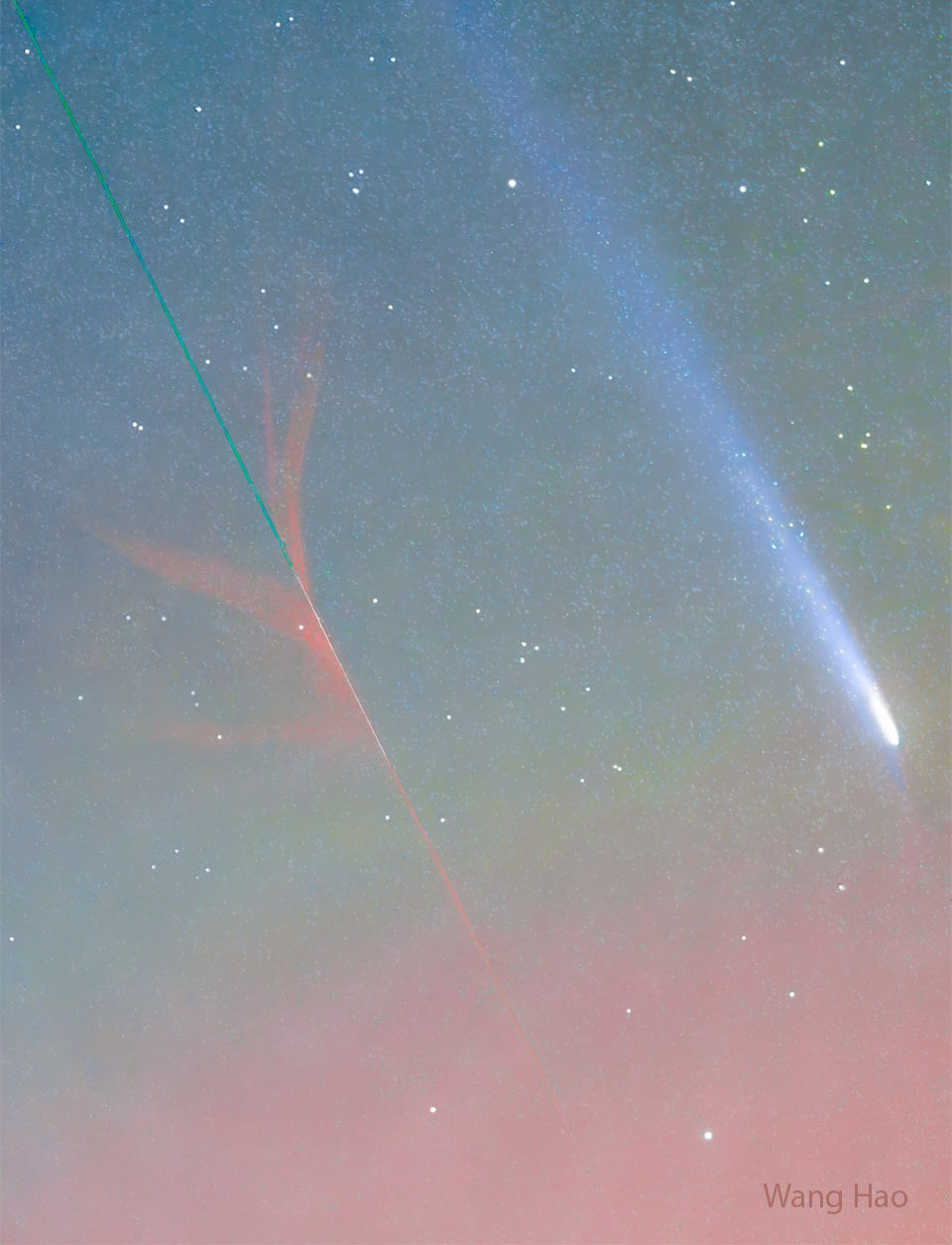 A star-filled sky has two streaks in the foreground. A green
and red streak toward the lower left was created by an ablating 
meteor, while the blue and white streak on the upper right is
the coma and tail of a comet. 
Please see the explanation for more detailed information.