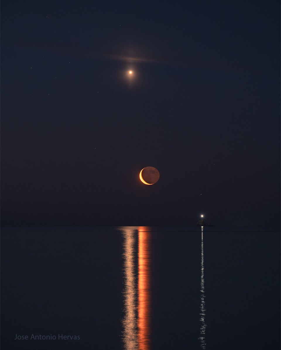 The featured image shows a night sky over some choppy
water. The planet Venus shines high in the night sky, while a faint
Saturn in on the far right. The crescent Moon is visible near the
image center. A bright boat beacon is also visible on the right.
All of these objects are reflected as lines in the foreground
water.
Please see the explanation for more detailed information.